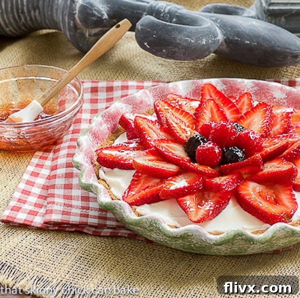 Strawberry Cream Cheese Pie with a bowl of glaze and a brush for application, showing the beautiful red sheen.