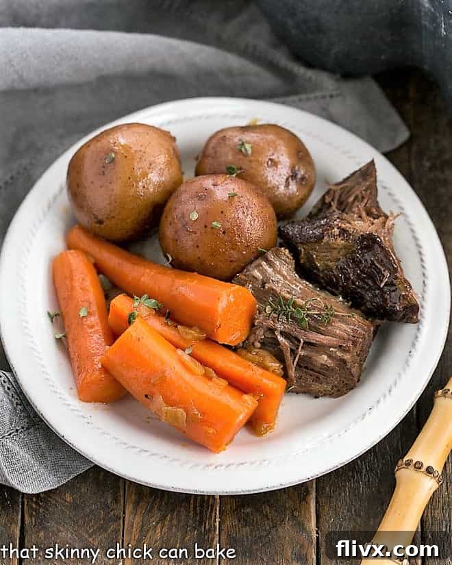 Overhead view of a comforting bowl of Instant Pot Beef Stew with chunks of beef, potatoes, and carrots, garnished with fresh herbs, on a white plate.