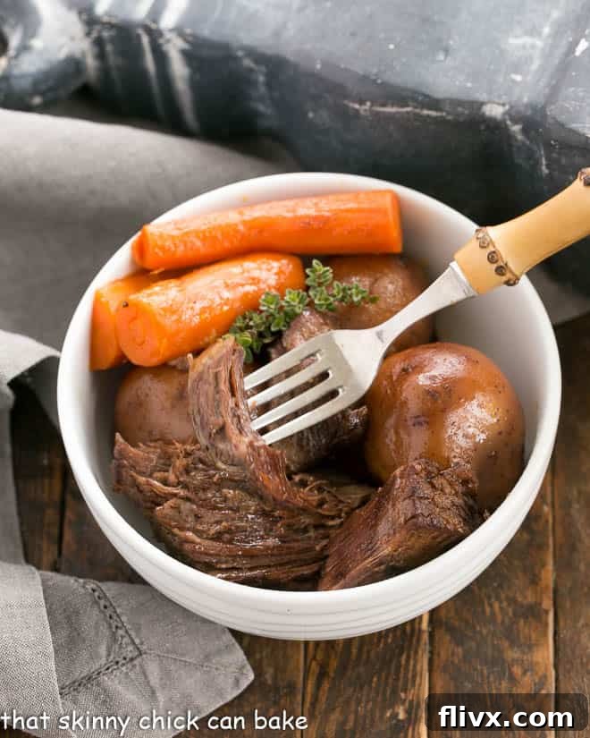 Close-up shot of pressure cooker beef stew in a white bowl, with a fork piercing a large, tender piece of stew meat, highlighting the rich broth and soft vegetables.