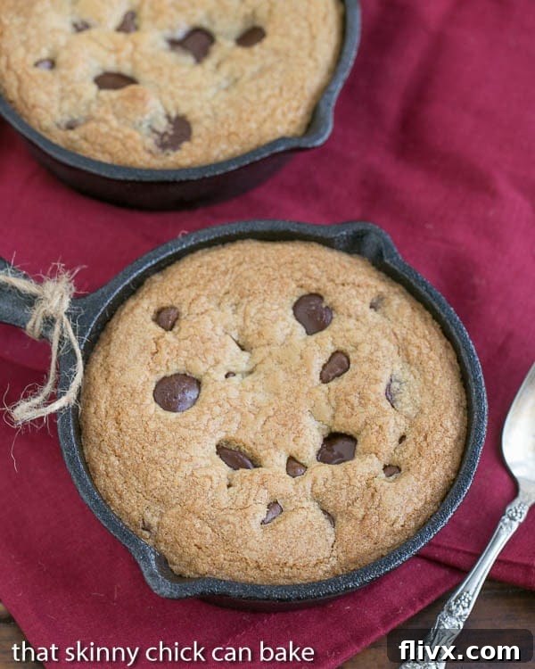 Two Skillet Chocolate Chip Cookies in small cast iron pans, fresh from the oven, ready to be served
