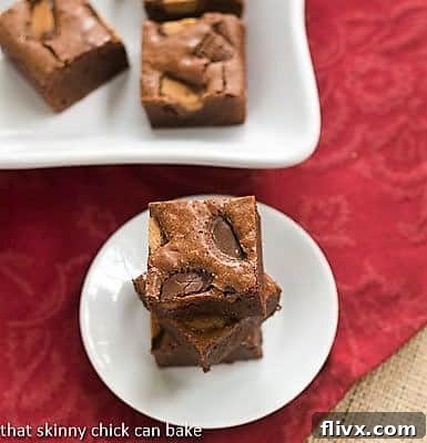 Stack of Fudgy Brownies with Reese's Chunks on a white plate, showcasing their decadent texture