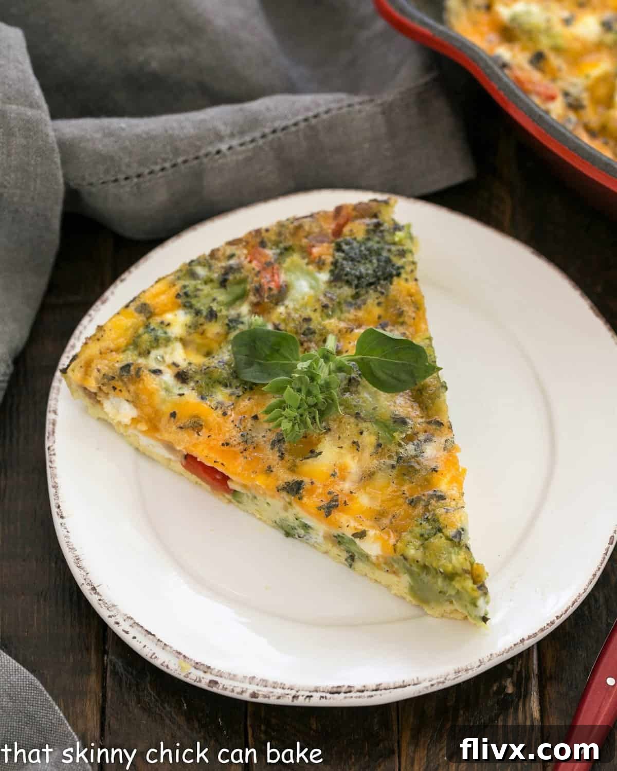 Overhead view of slice of broccoli frittata on a round white ceramic plate, garnished and ready to serve.