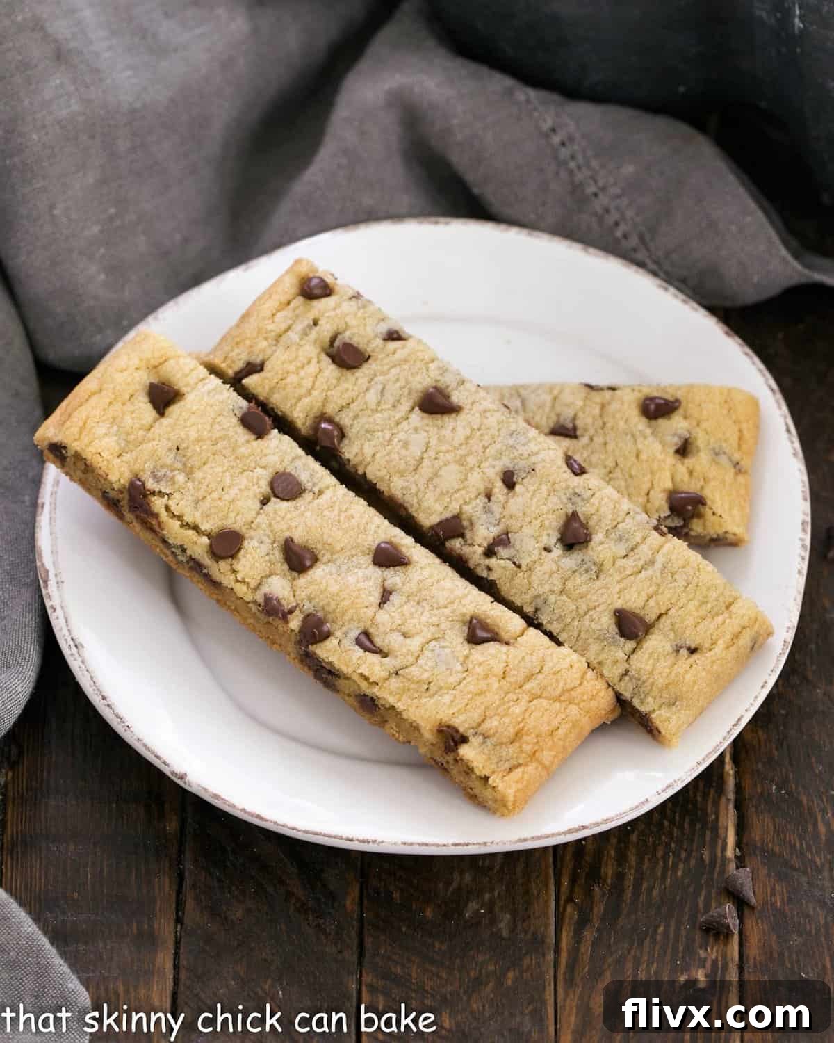 A small white ceramic plate holds several perfectly baked chocolate chip cookie dippers, inviting a delicious treat.