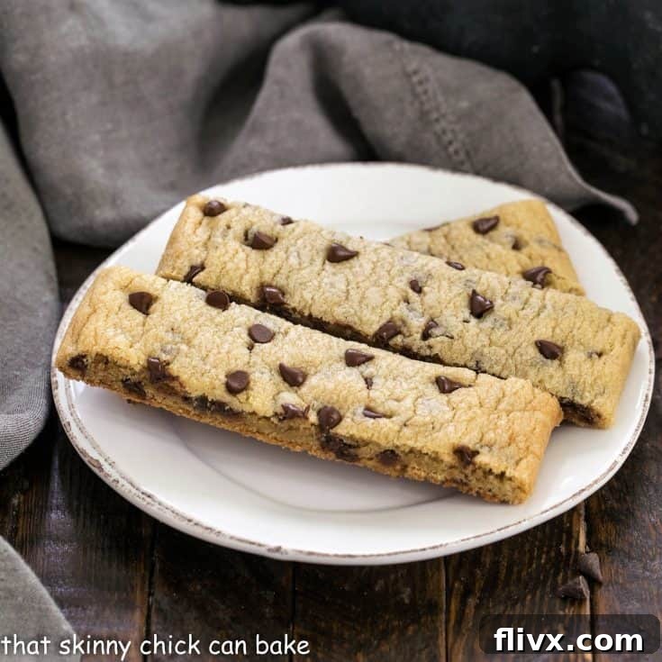 Three perfectly baked chocolate chip cookie sticks resting on a small white plate, inviting a sweet indulgence.