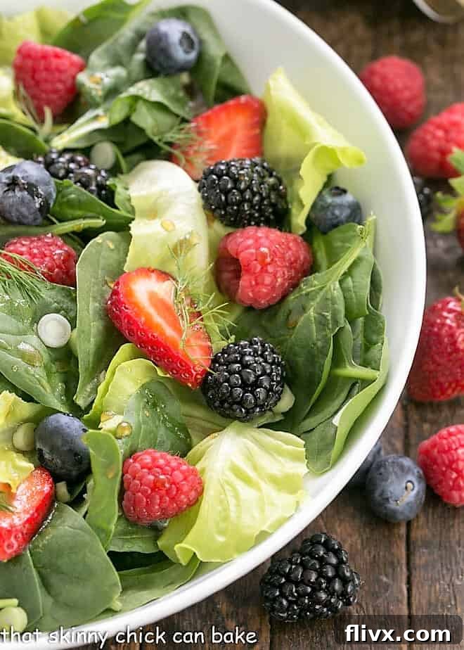 Close view of spinach salad ingredients in a white bowl.