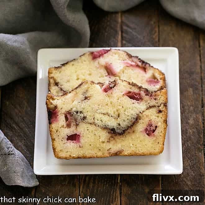 Two perfectly sliced pieces of moist rhubarb bread on a small square white plate, showing the beautiful cinnamon swirl within.