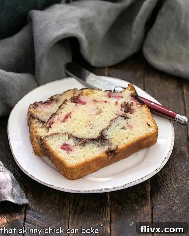 Two exquisite slices of rhubarb bread, showcasing a rich cinnamon swirl, served on a round white plate. Perfect for breakfast or a sweet snack.