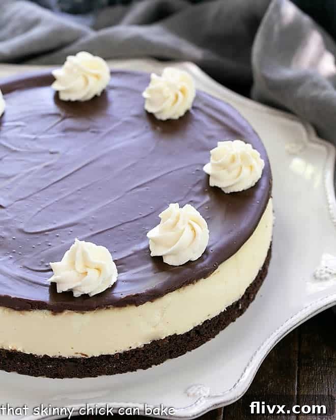 Close view of half of a Baileys cheesecake on a white cake plate.