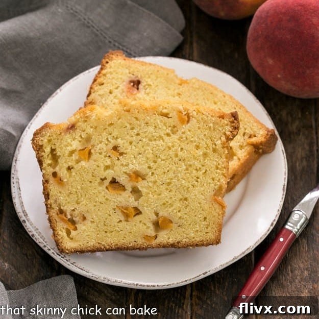 Overhead view of 2 slices of peach cake on a white plate with a red handled fork