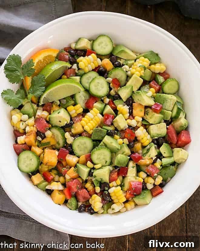 Second step for Southwest Chopped Salad: all chopped ingredients, including avocado and black beans, tossed together in a large bowl, ready to be served.