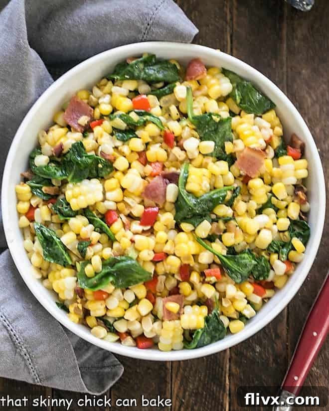 Overhead view of skillet corn with bacon in a white serving bowl, showcasing the vibrant ingredients.