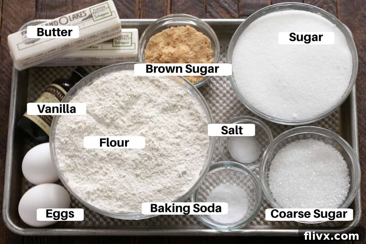 Giant Sugar Cookie Ingredients neatly laid out with labels on a metal sheet pan, showing flour, sugars, butter, eggs, and vanilla.