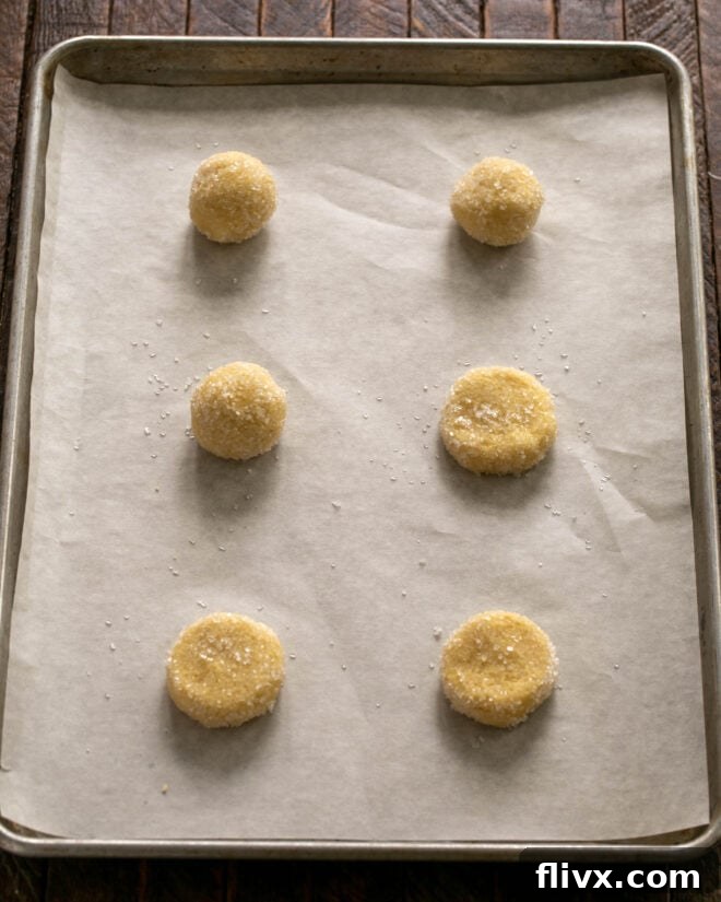 Step 5: Scoop large dough balls, roll them in coarse sugar, and gently flatten before baking.