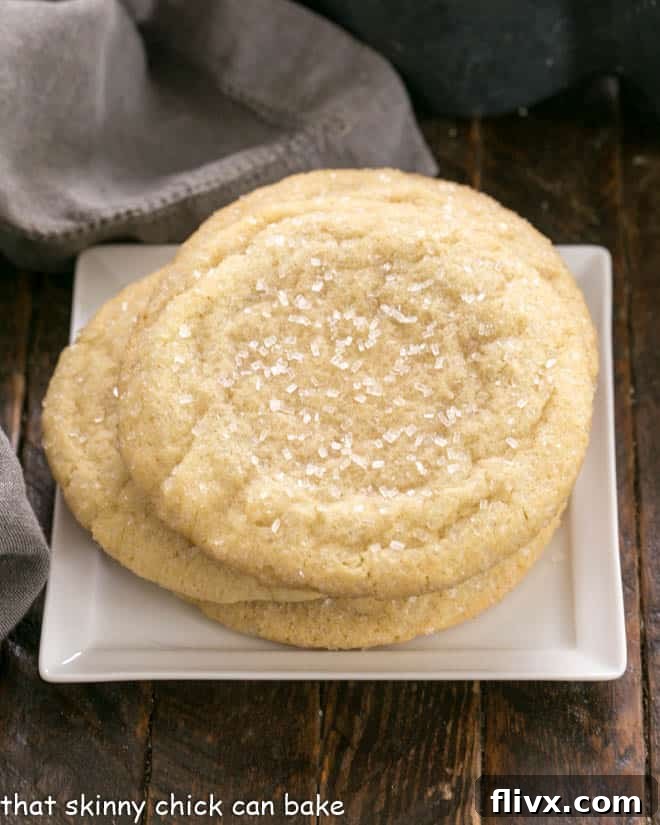 Overhead view of a stack of Big Homemade Sugar Cookies on a square white plate, showing their golden color and textured tops.