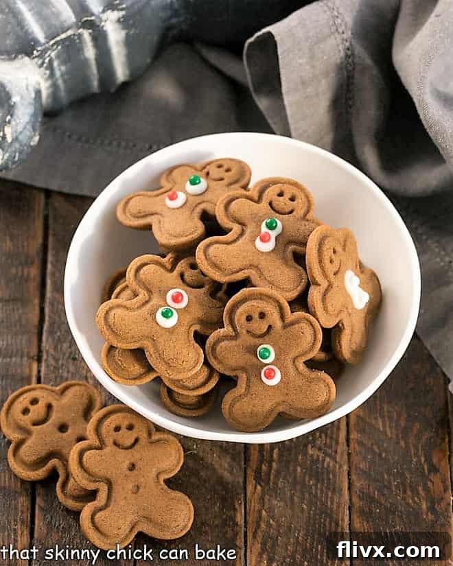 A small white bowl brimming with adorable mini gingerbread men cookies, each perfectly baked and ready for a festive display.