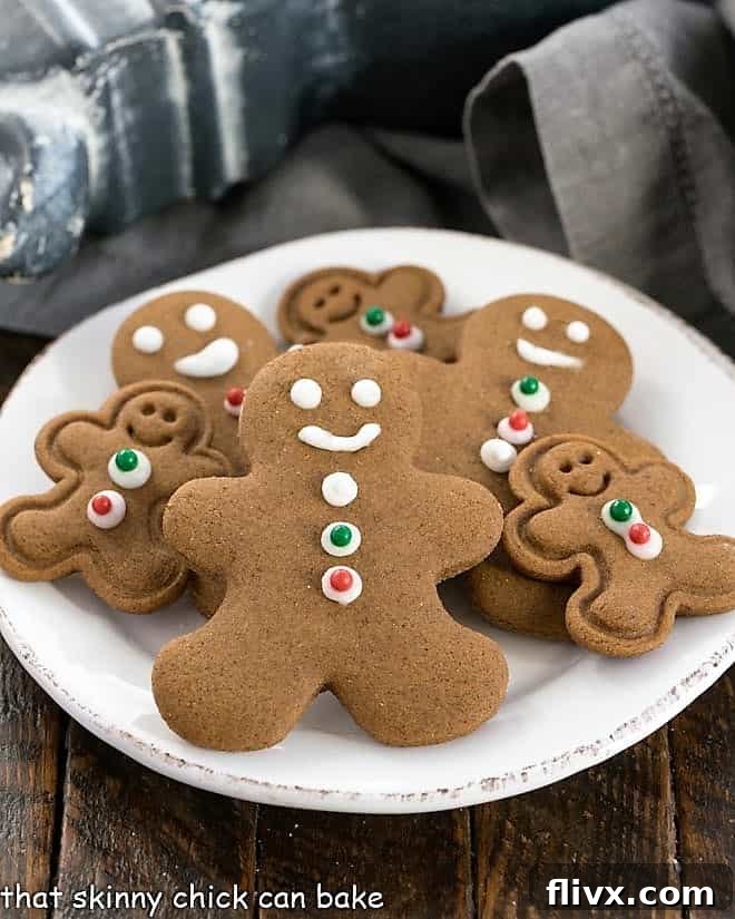 A charming collection of different sized gingerbread man cookies arranged appealingly on a classic round white plate, ready for festive enjoyment.