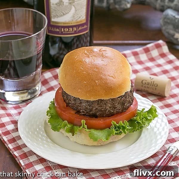 California burger on a white plate over a checked napkin