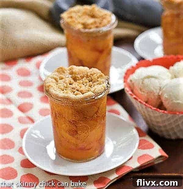 Peach Crisp in Jars next to a bowl of ice cream, showing a delightful summer dessert presentation.