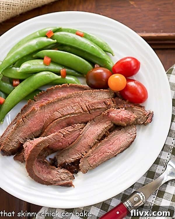 Sliced Korean Beef Recipe presented beautifully with vibrant sugar snap peas and cherry tomatoes for a complete meal.