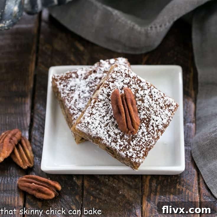 Two beautifully golden pecan bars resting on a small square white plate, highlighting their delightful texture and topping.