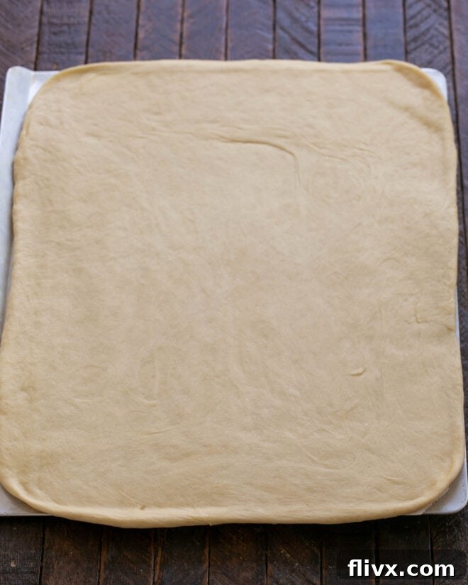 Fluffy Orange Glazed Rolls 11 Dough rolled out into an 18 x 12-inch rectangle on a lightly floured surface.