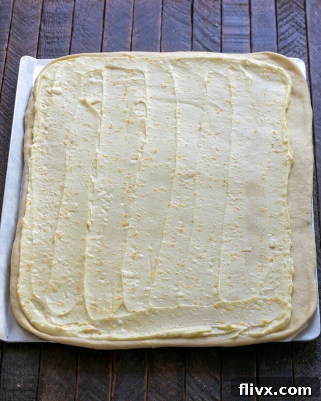 Fluffy Orange Glazed Rolls 12 Half of the prepared orange filling spread evenly over the rolled-out dough.