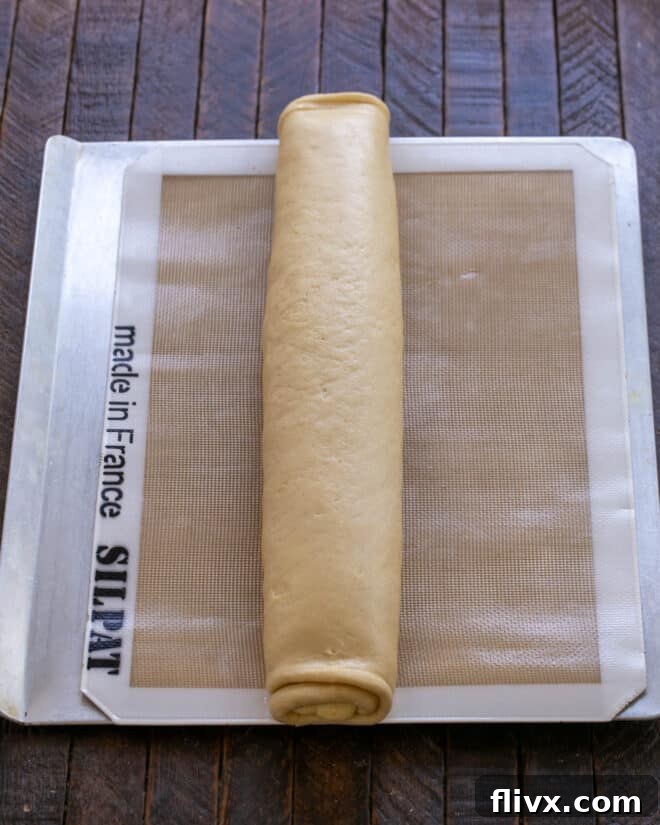 Fluffy Orange Glazed Rolls 13 Dough carefully rolled into a tight cylinder from the long side.