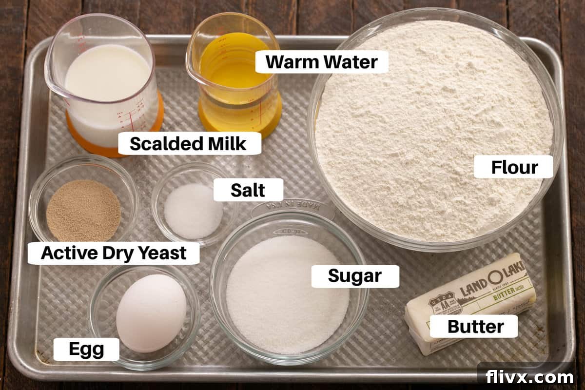Fluffy Orange Glazed Rolls 2 Ingredients for Orange Rolls Dough laid out with labels on a metal sheetpan, including flour, sugar, butter, egg, yeast, and milk.