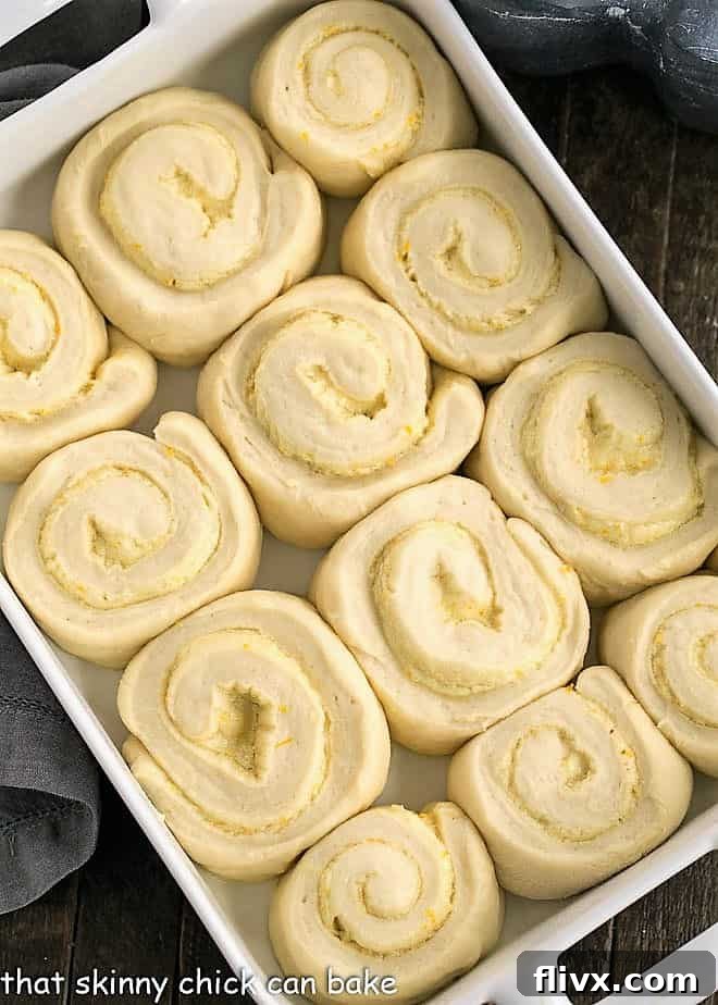 Orange Sweets Rolls - a delicious twist on cinnamon rolls filled and iced with orange zest infused frosting! Sweet Orange Rolls after their second rise, perfectly puffed up in a 9 x 13 ceramic baking dish, ready for the oven.