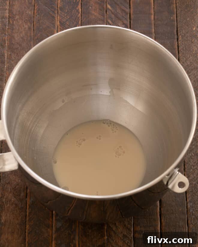 Fluffy Orange Glazed Rolls 5 Activated yeast mixture added to a stand mixer bowl.