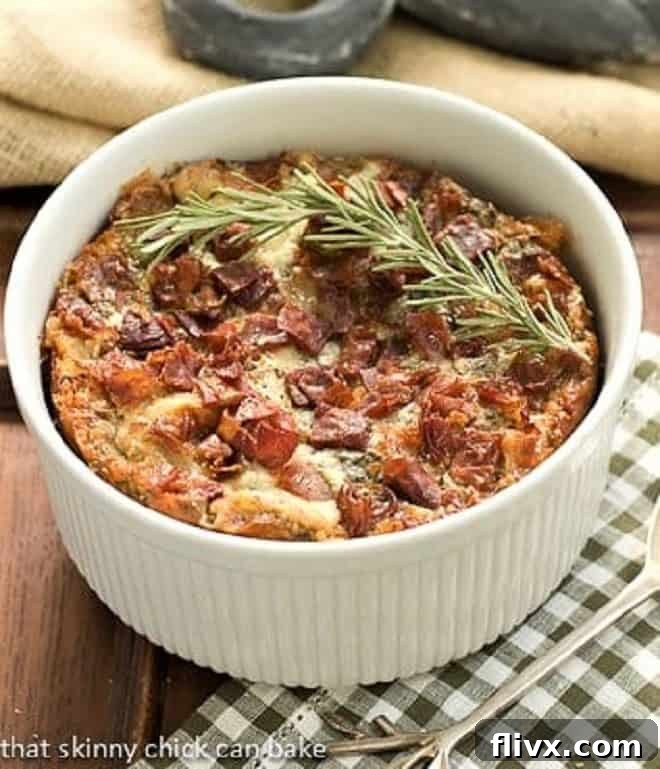 Delicious Prosciutto, Gorgonzola, and Rosemary Strata in a round casserole dish, garnished with a fresh sprig of rosemary, ready to be served for breakfast or brunch