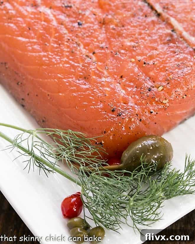 Close up of gravlax on a white platter with dill garnish.