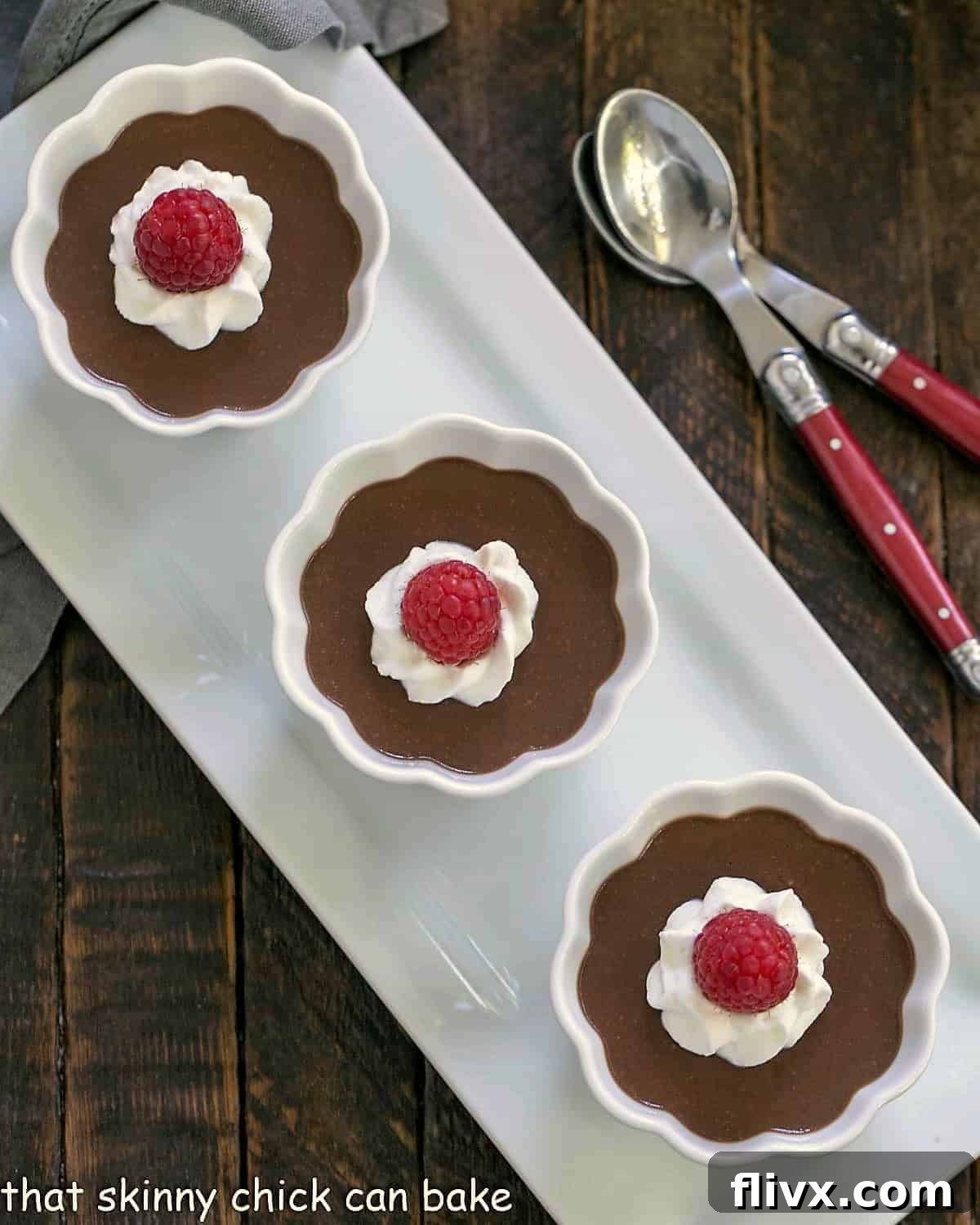 Three perfectly portioned ramekins of Italian chocolate pudding, presented neatly on a white ceramic tray, showcasing their smooth texture and readiness for serving.
