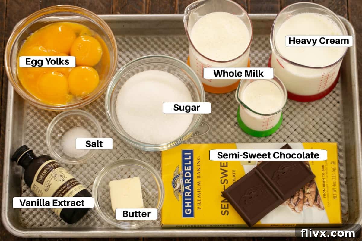 A carefully arranged metal sheet pan displaying all the essential ingredients for Italian Chocolate Pudding, including chocolate, eggs, milk, and cream, each clearly labeled for easy identification.
