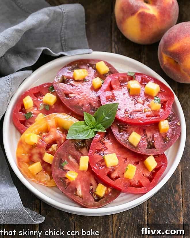 Overhead view of Tomato Salad with Peach and Basil Vinaigrette on a white plate