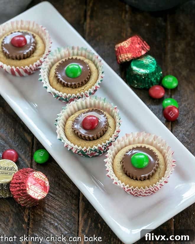 Close-up of golden brown Peanut Butter Cookie Cups with melted chocolate centers, arranged neatly on a white ceramic tray, highlighting their perfect two-bite size and inviting texture.