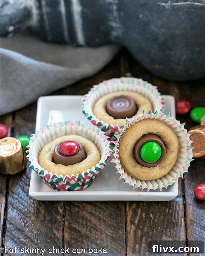 A charming display of various Peanut Butter Cookie Cups on a square white plate, some adorned with colorful M&M's, showcasing the customizable nature and irresistible appeal of these mini desserts.