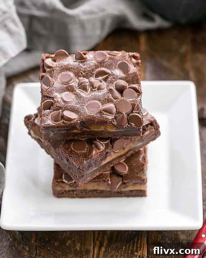 A beautifully presented stack of luscious caramel chocolate brownies on a square white plate, showcasing their rich texture and perfect layers.
