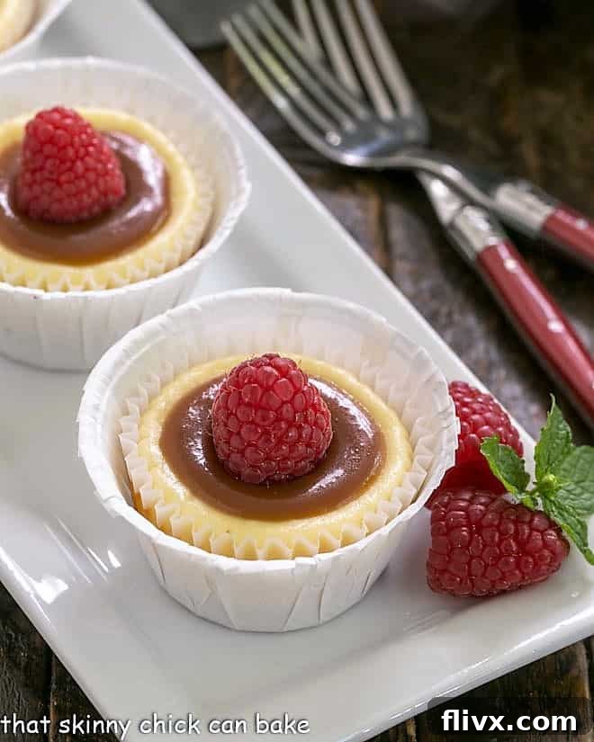 Two exquisite Caramel Topped Mini Cheesecakes on a white tray, highlighting their perfect individual size and decadent topping.