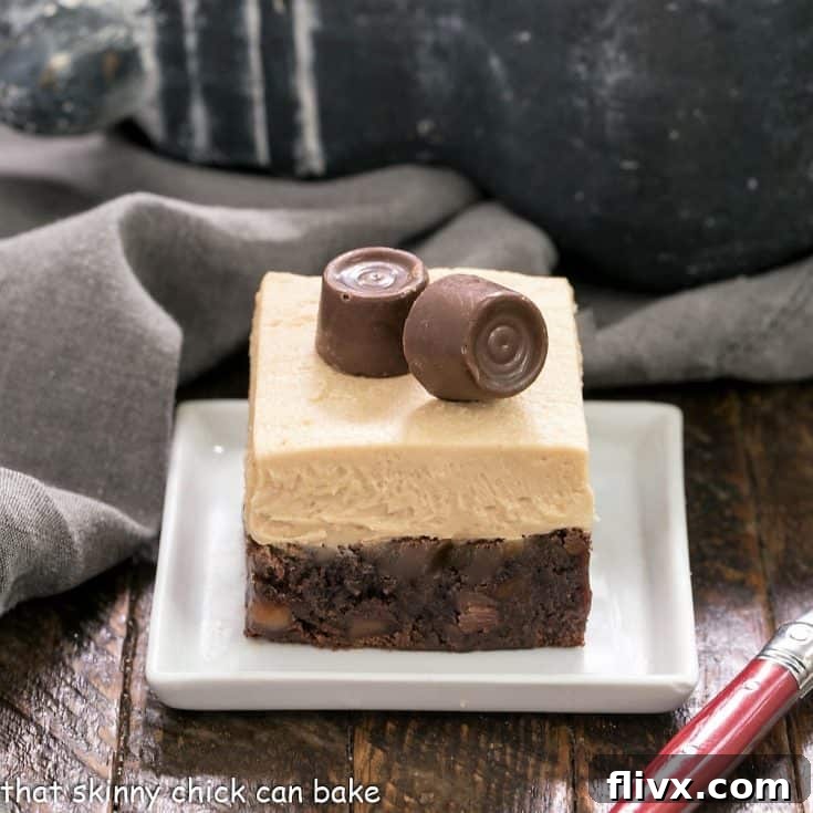 A caramel brownie with caramel buttercream on a square white plate next to a red handle fork