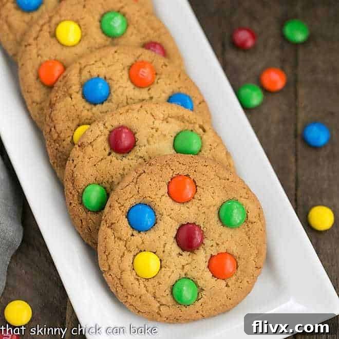 A selection of warm, freshly baked Classic M&M Cookies presented on a pristine white ceramic tray, highlighting their irresistible appeal.