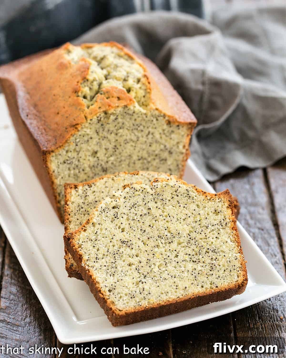 Sunshine Lemon Poppy Seed Loaf 2 Freshly sliced lemon poppy seed loaf cake presented beautifully on a rustic ceramic tray, highlighting its tender crumb and plentiful poppy seeds.