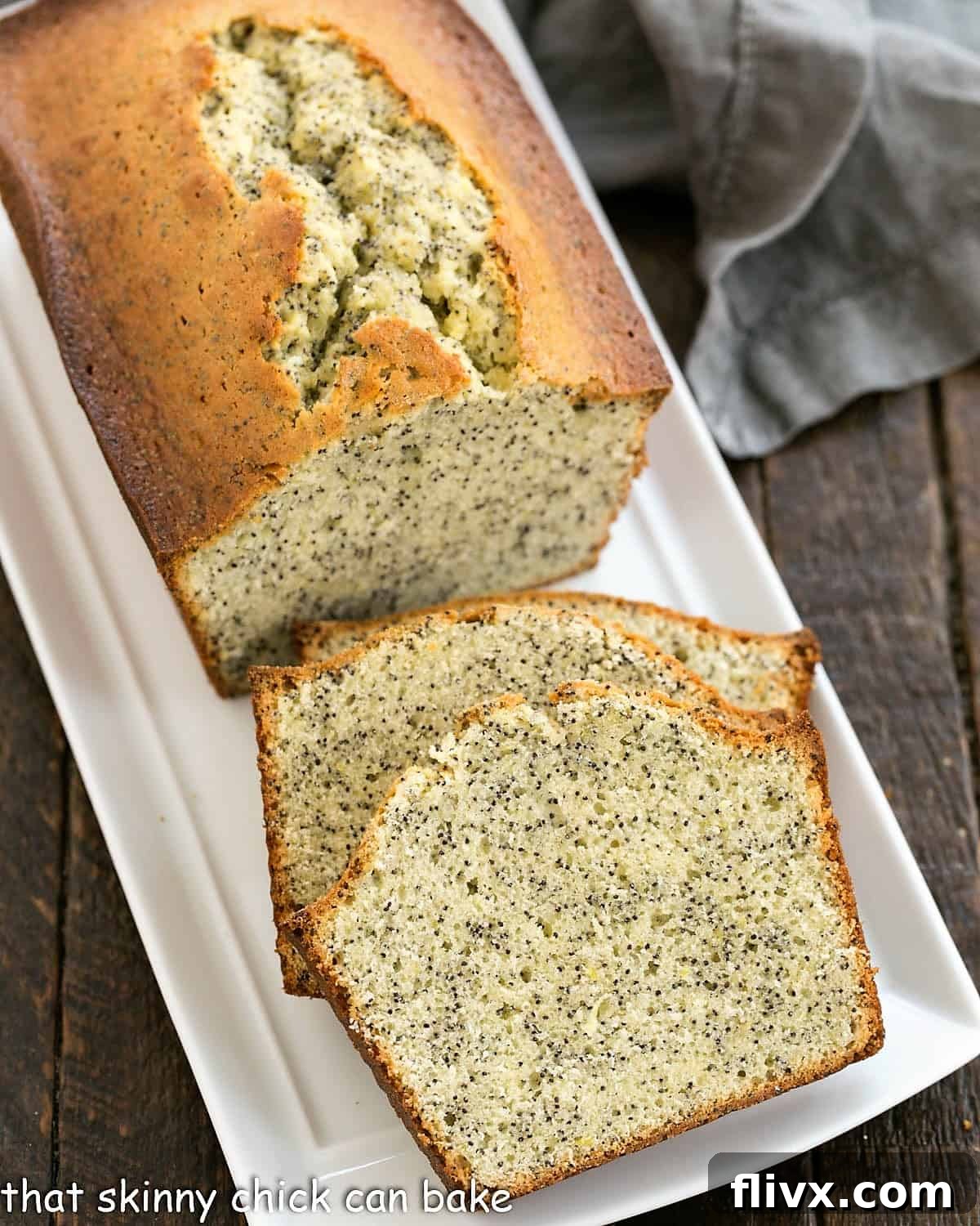 Sunshine Lemon Poppy Seed Loaf 4 A beautifully baked and sliced lemon poppy seed loaf cake resting on a pristine white ceramic tray, ready to be served.